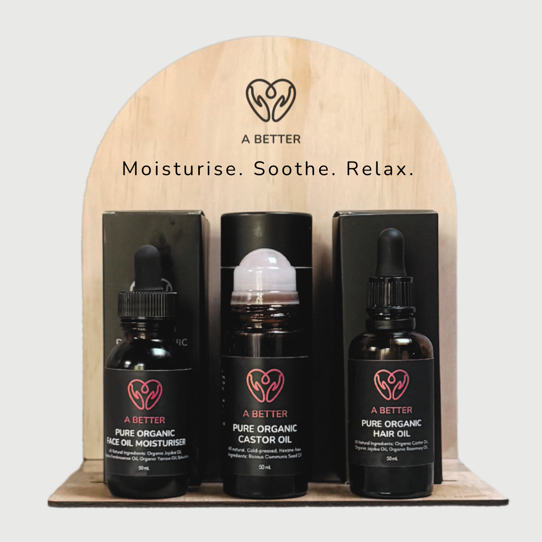 Three bottles of 'A Better' organic oils on a wooden stand with branding and product names.