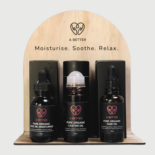 Three bottles of 'A Better' organic oils on a wooden stand with branding and product names.