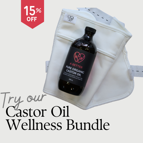 Castor oil bottle lying on waist wrap with text try our castor oil wellness bundle