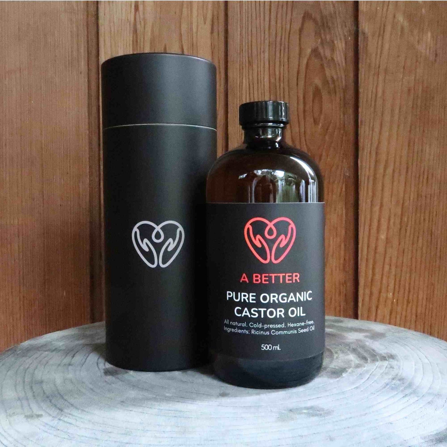 Bottle and cylinder of A Better Pure Organic Castor Oil with a timber background